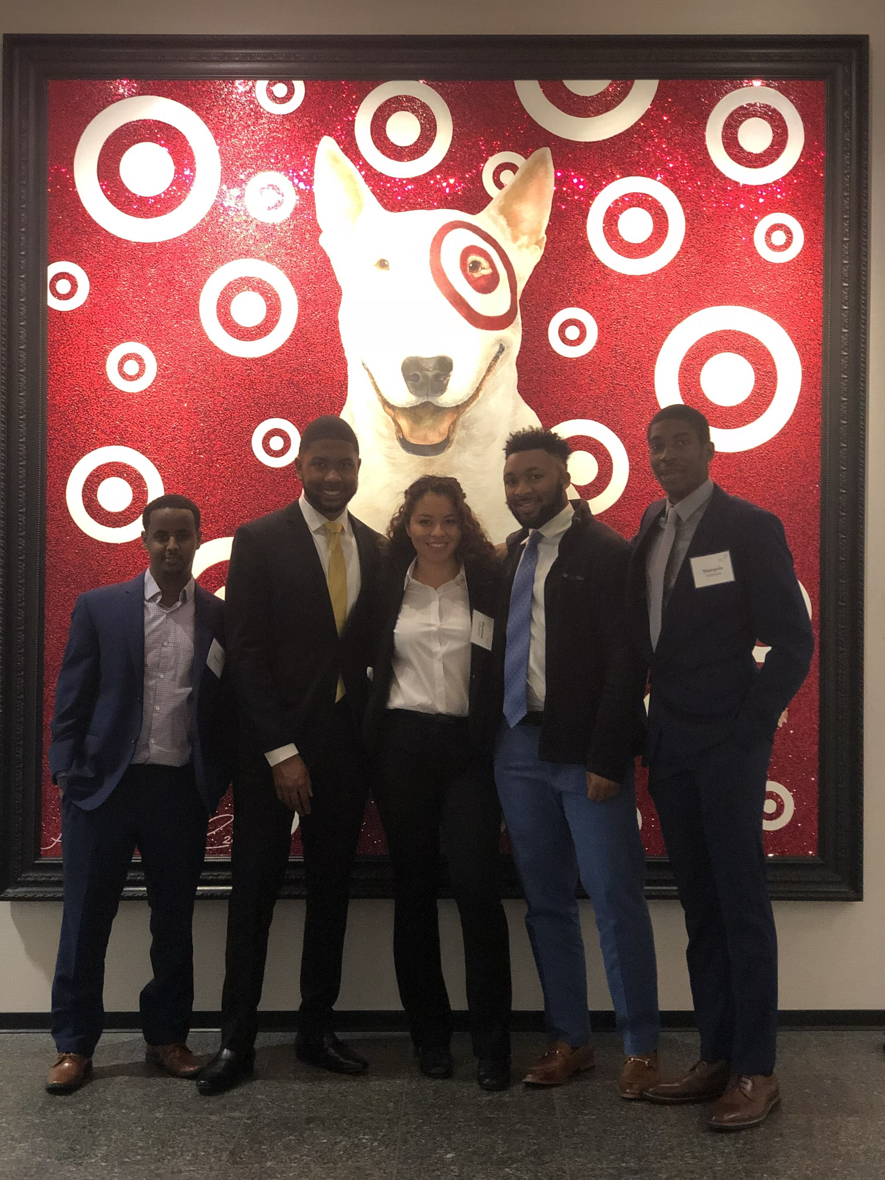 Shyanne Yellowbird poses with Career Prep peers and a portrait of Bullseye, the Target mascot, at MLT's Interview and Analytical Skills seminar at Target. 